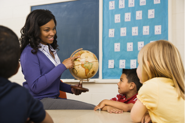 teacher sharing a globe with students