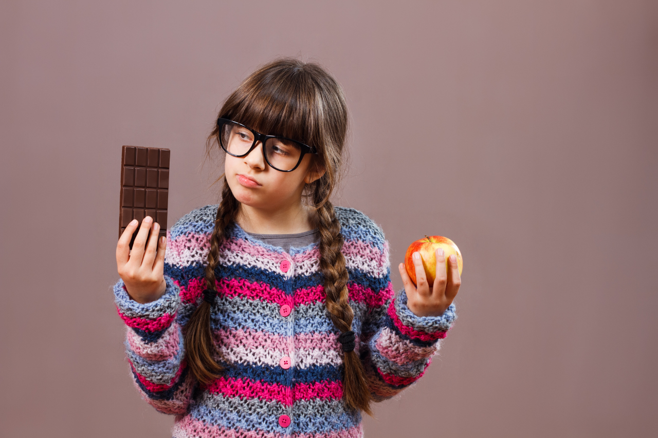 girl choosing between candy and apple