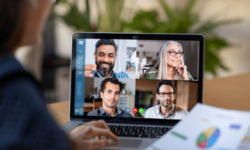 closeup of a laptop with 4 adults in gallery view during a virtual meeting
