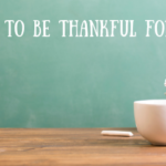 a teacher's desk with coffee cup and file folders and a chalkboard in the background that says 10 reasons to be thankful for teachers