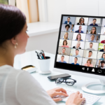 woman is facing desktop computer with gallery view of 36 other adults who are attending professional development for teachers.