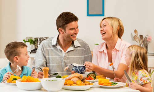 white family talking at the dinner table with young boy, brunette father, blond mother, and young girl