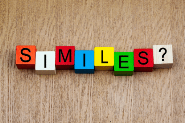 alphabet blocks on a wooden table; the blocks spell "similes?"