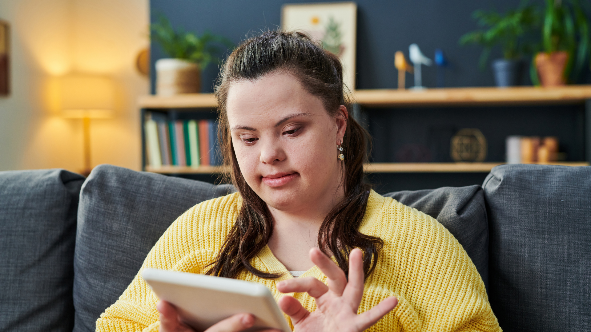 young woman in yellow shirt is using a tablet to communicate