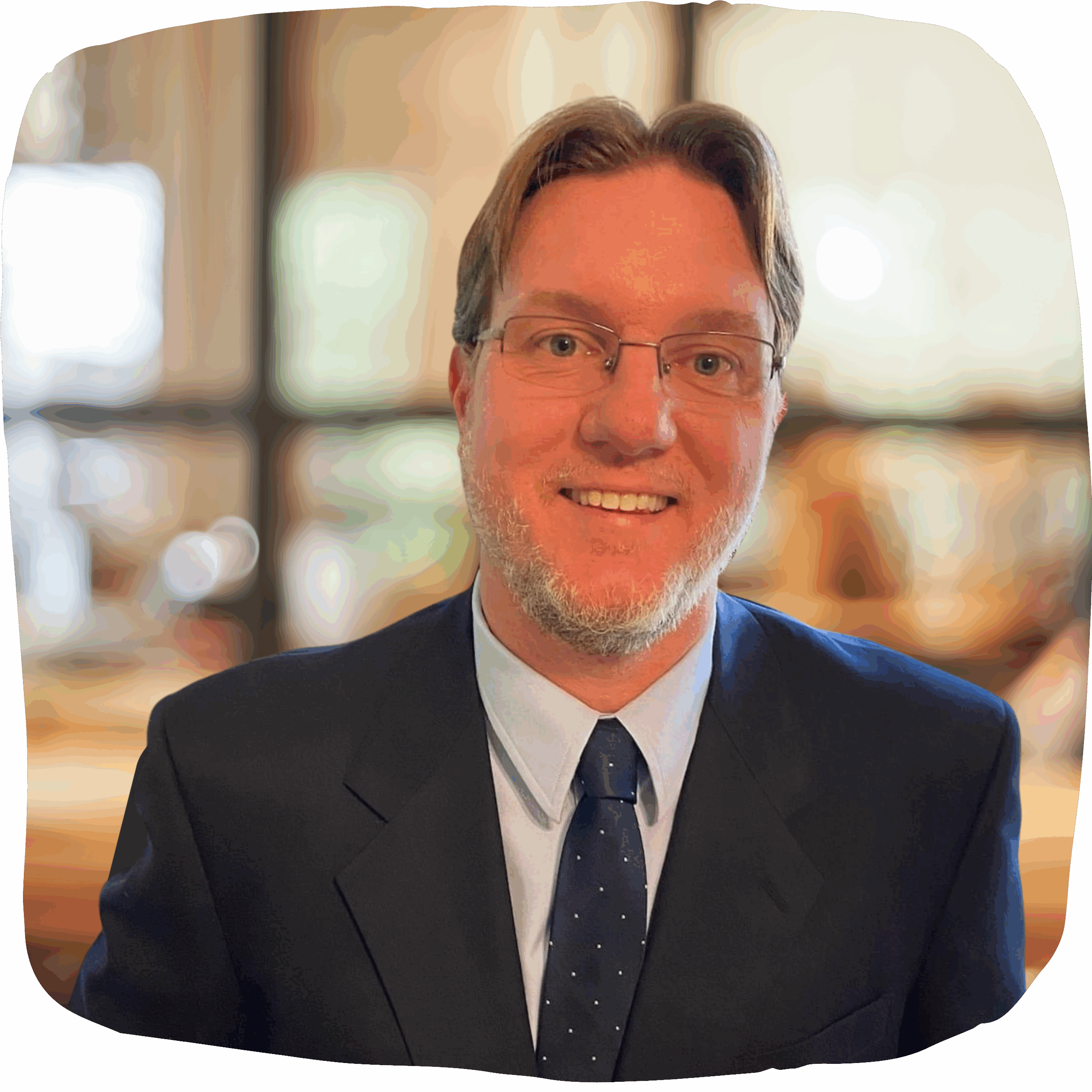 Daniel Biegun headshot headshot of a man wearing a blue suit and tie