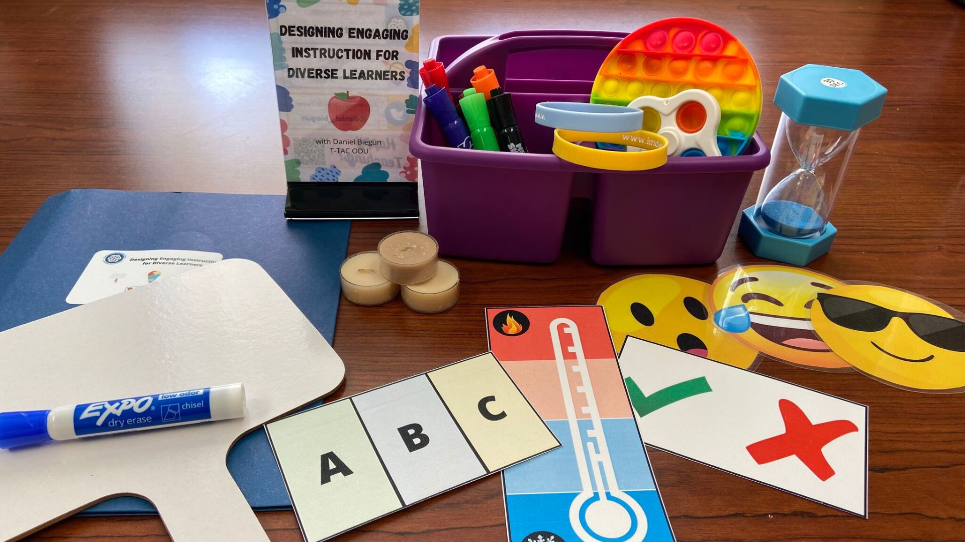 collection of colorful teaching tools including whiteboard, markers, pinch cards, and fidgets