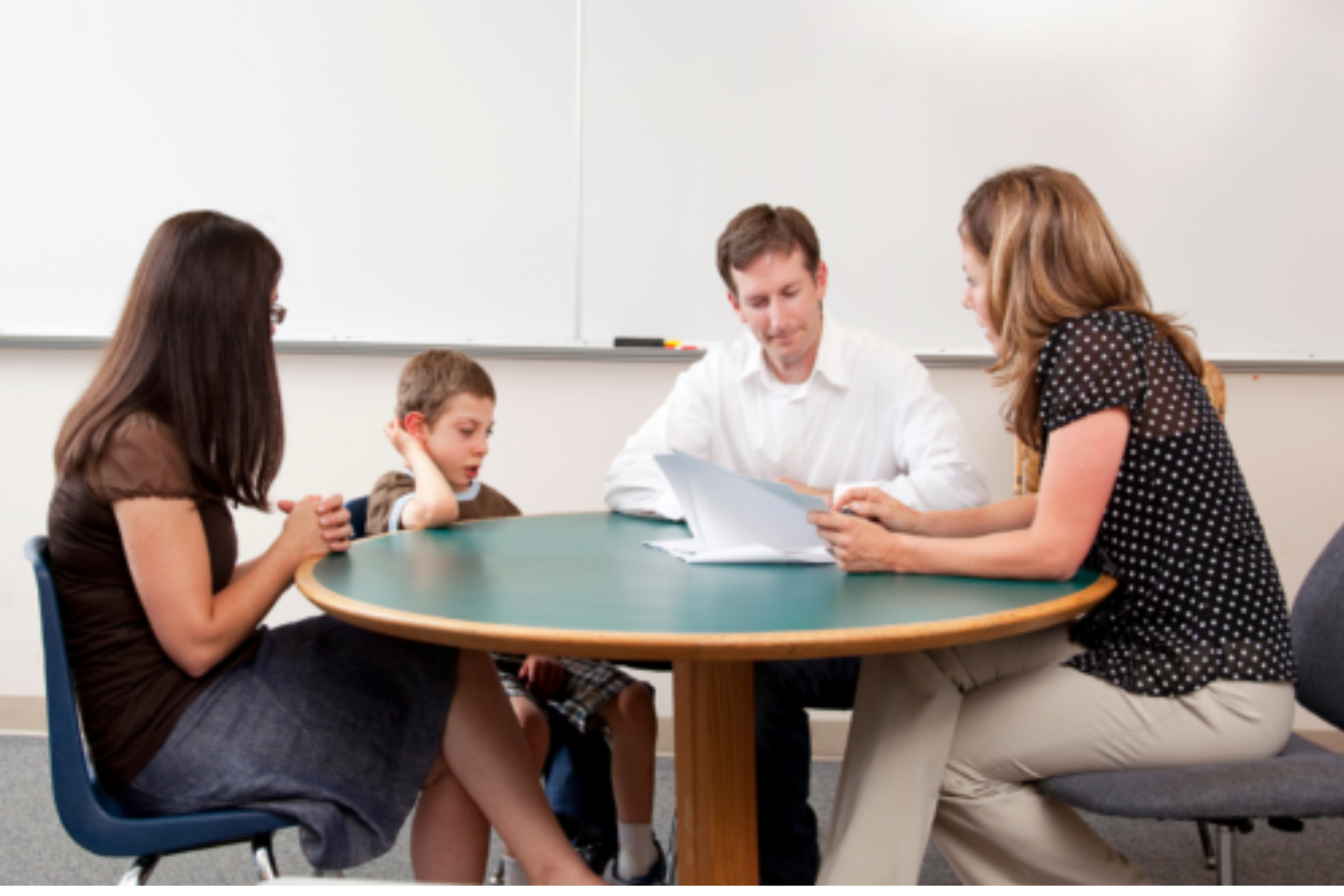 teacher, student, father, and administrator attending IEP eeting at a round table