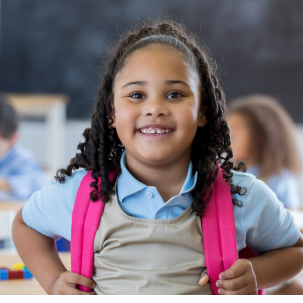 young african american female student with a pink backpack face the camera and smiles